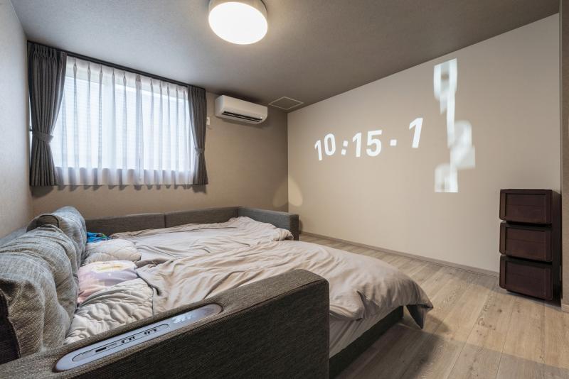 寝室、シアタールーム:9帖の主寝室、1面にプロジェクター用クロスを採用し夜はホームシアターに