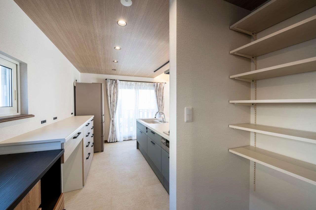 キッチン、食品庫：リビングからの死角には段の高さにもこだわった可動棚でパントリーを造作