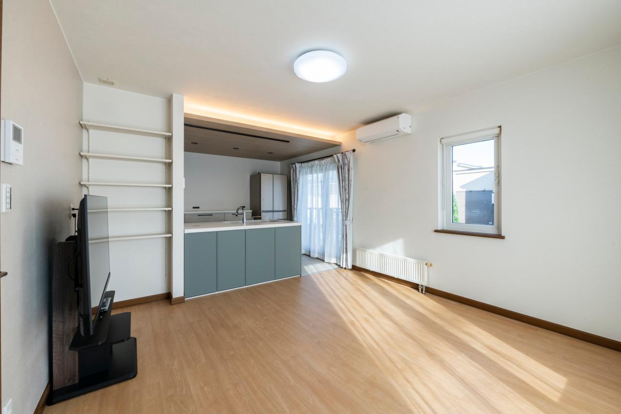 ダイニング、キッチン、照明：キッチン上には木目調に割り分けた下がり天井と間接照明