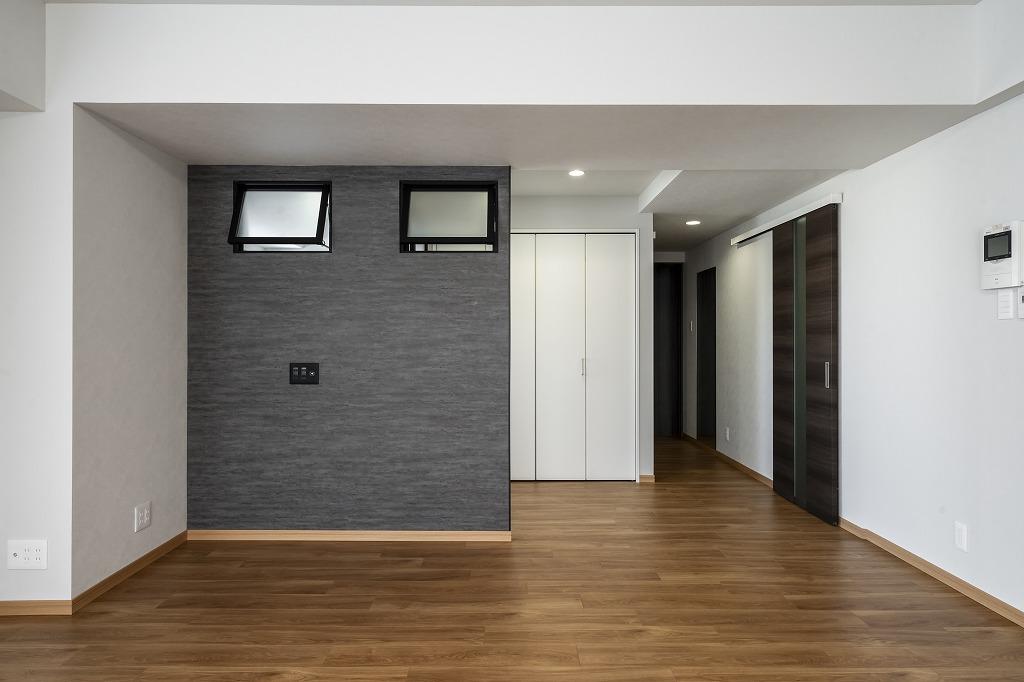 リビング：TVボードはグレーのアクセントクロスを採用、室内窓で明るさも担保