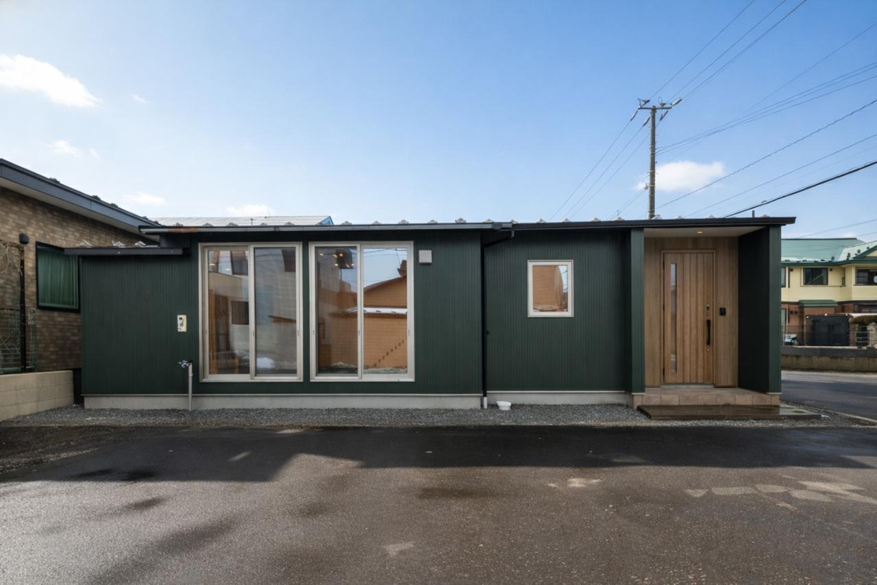 モスグリーンとブラウンの調和が美しいコテージの様な外観