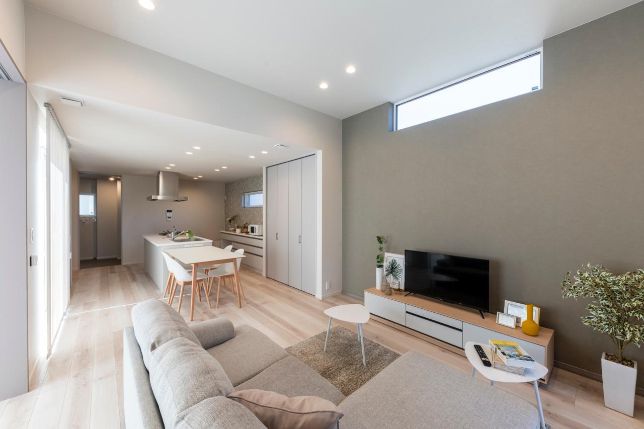 リビング、壁紙：落ち着いたグレージュのアクセントクロスで貼り分けたリビングの一面