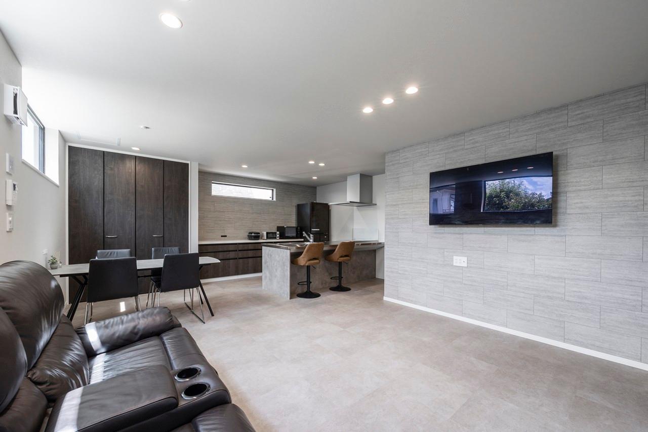 リビング、ダイニング、キッチン：スマートに生活感を隠す壁掛けテレビですっきりとみえるリビング