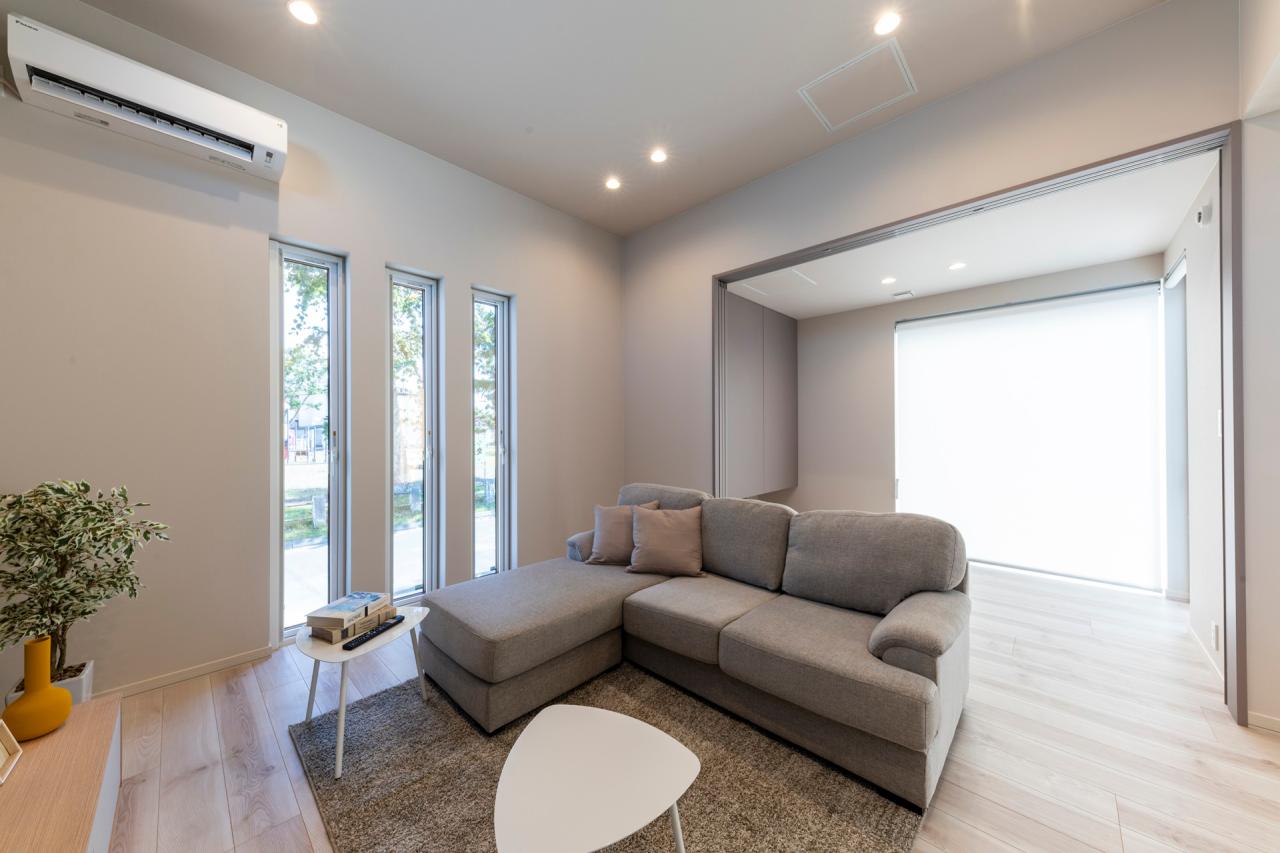 リビング、窓：ハイ天井とスリット開口で視線が縦に抜け、より広がりのあるリビング