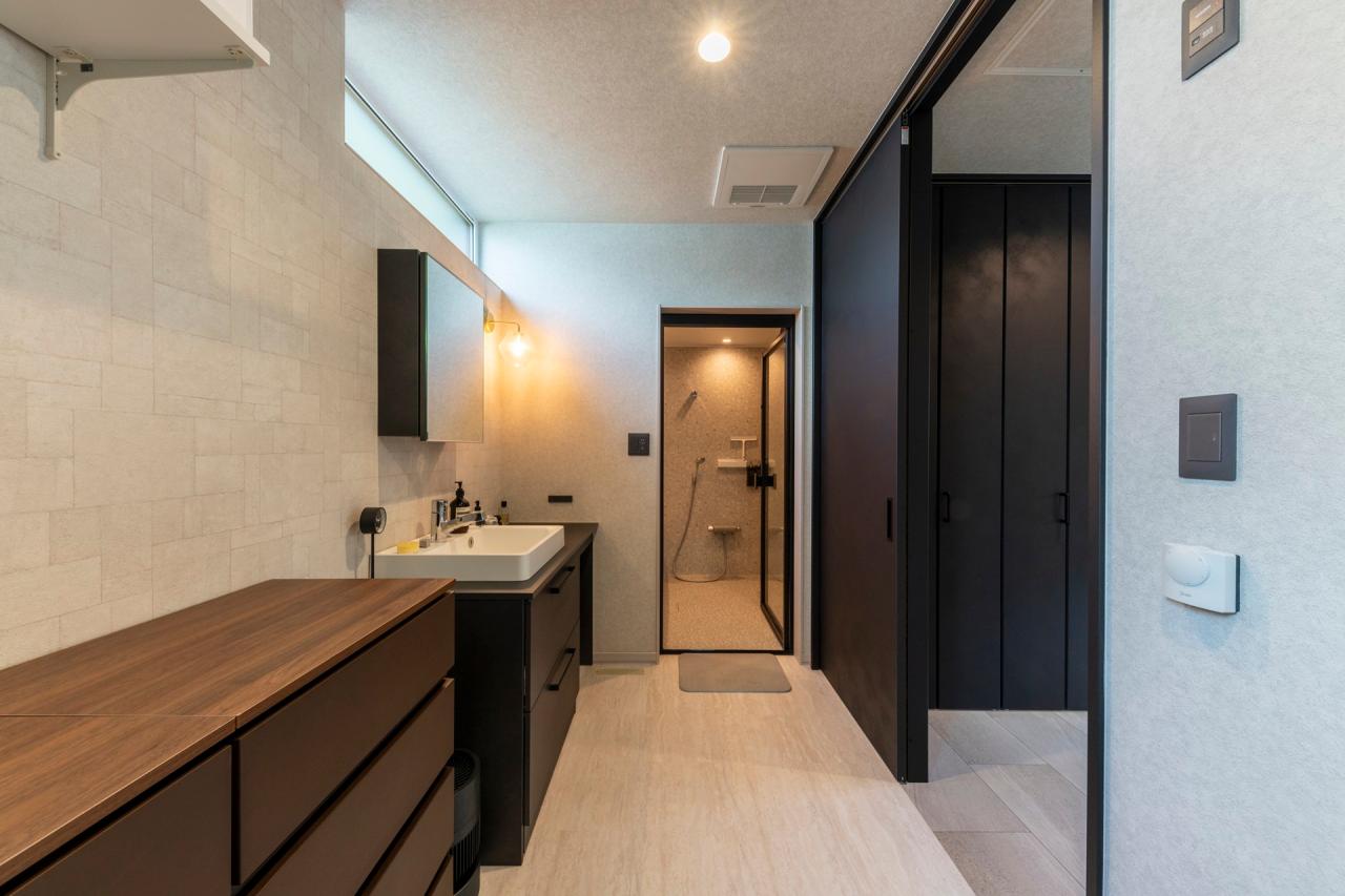 バスルーム、ラバトリー・洗面所、脱衣室：回遊式の水回りは収納をうまく配置し生活感ゼロの空間に