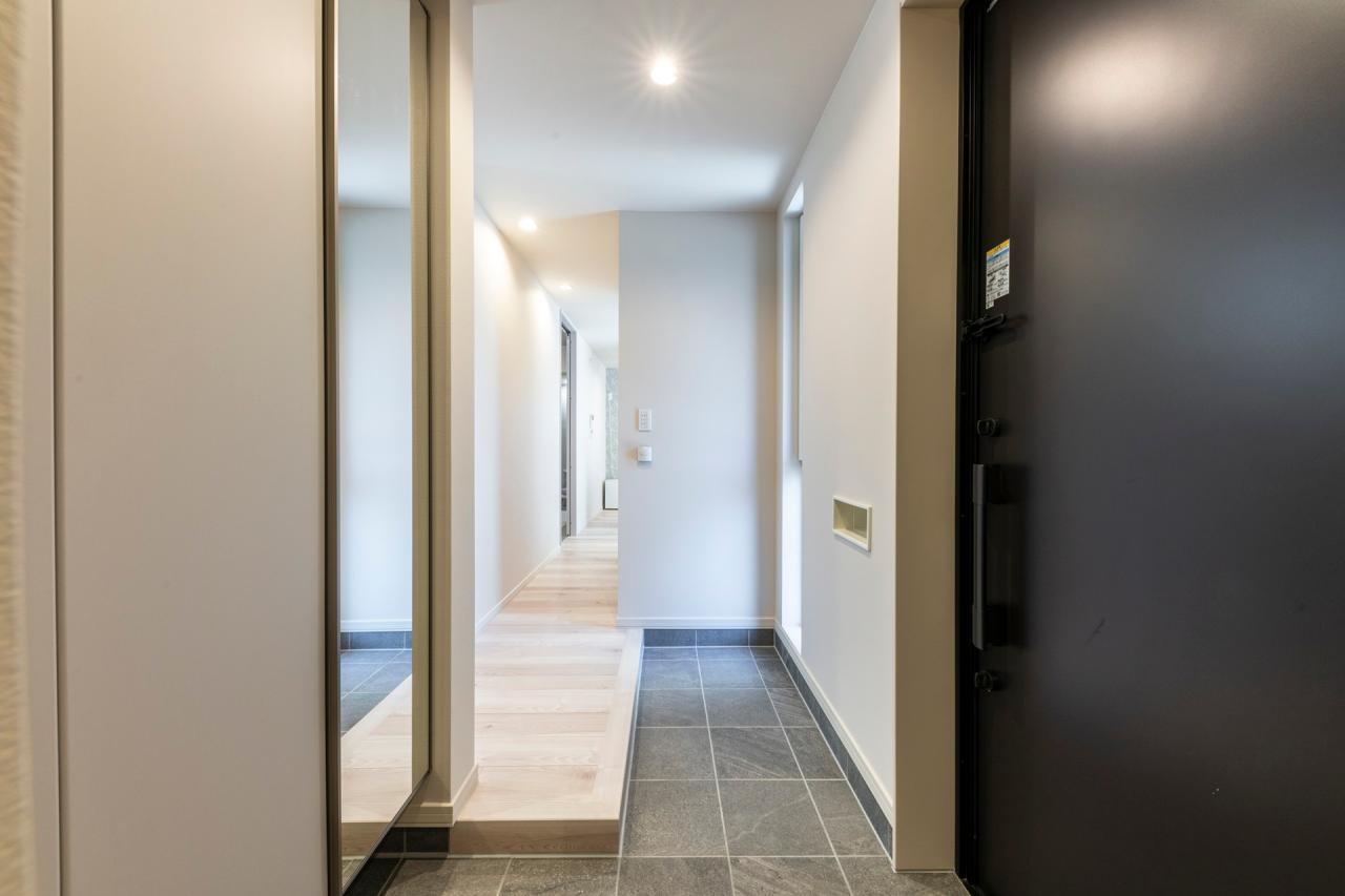 玄関、ホール：間口が広く複数人で同時に靴の脱ぎ履きが出来るL型框の玄関