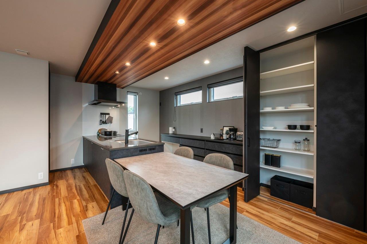 ダイニング、キッチン：黒で縁取った木目調の下がり天井が空間のアクセントに