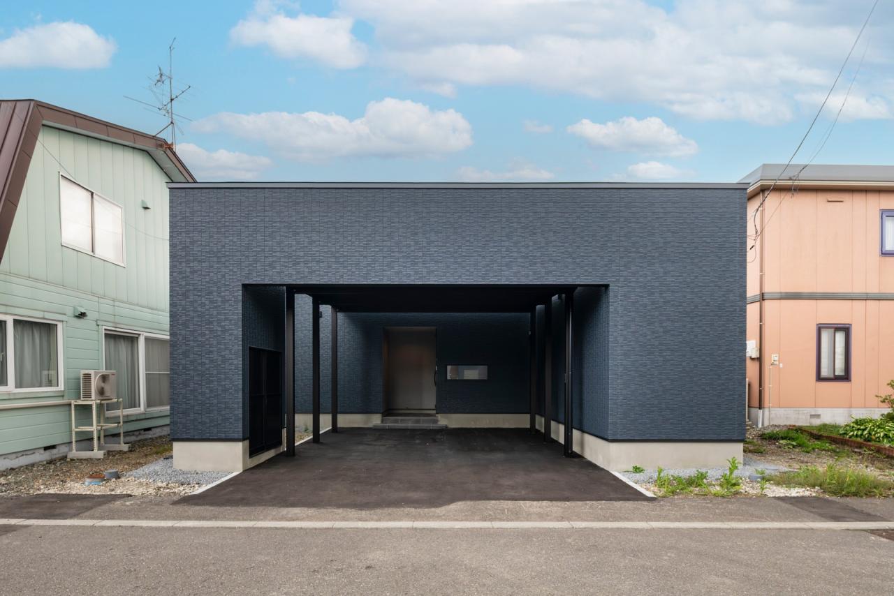 大型のカーポートを内包した門掛けデザインの外観