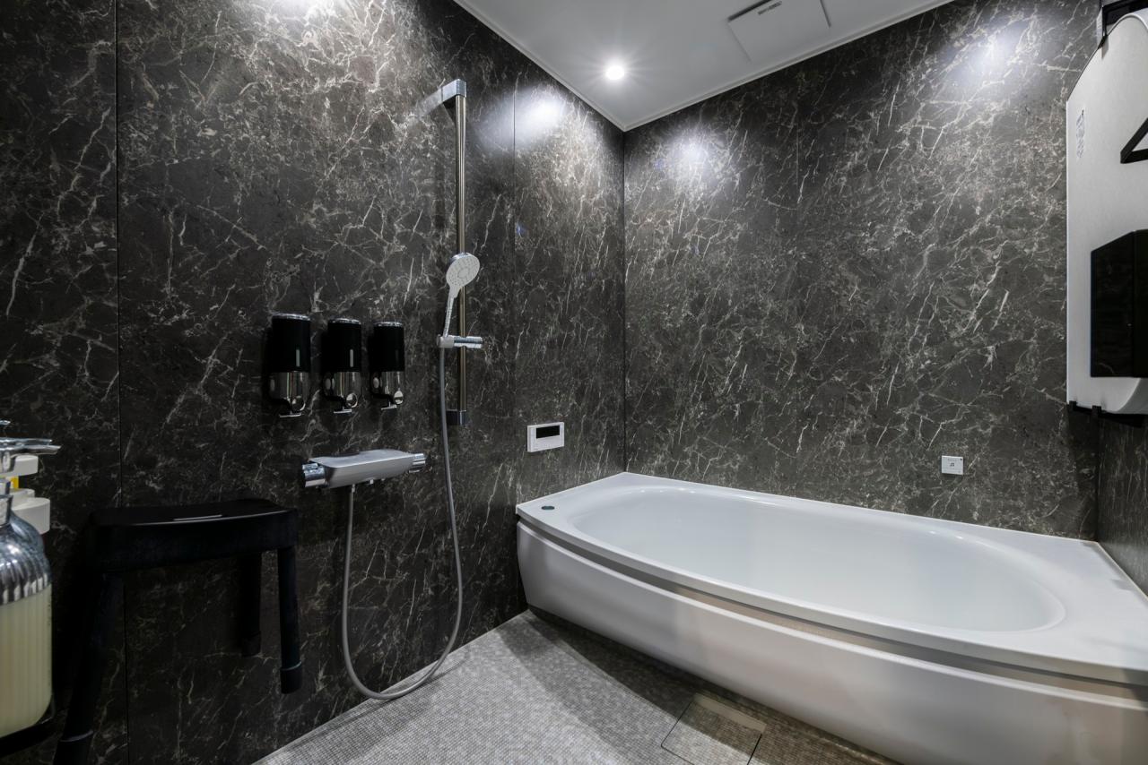 ブラックの石目が高級感を演出する浴室はTOTOのサザナシリーズ