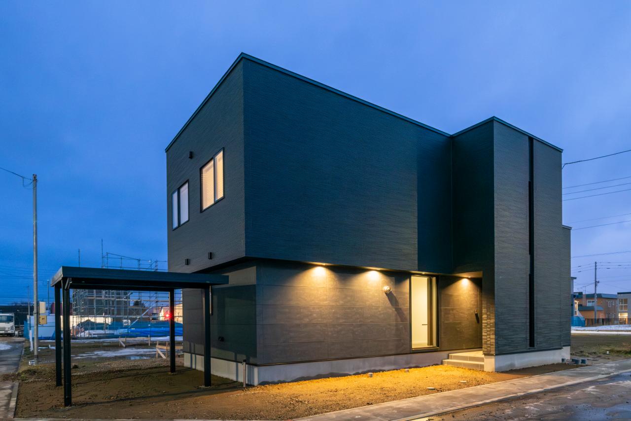 外観：オーバーハングが生み出す陰影が、夕闇の中でいっそう際立つデザイン