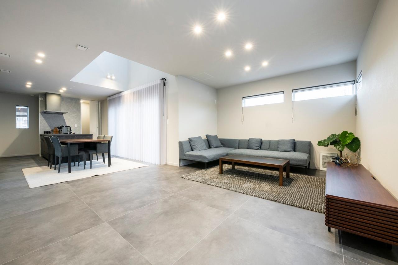 リビング、ダイニング、吹き抜け：L型配置で居心地よく緩やかにゾーニングされたLDK