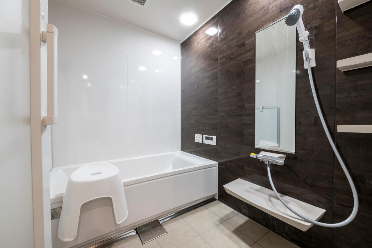 バスルーム：ブラウンのアクセントパネルが落ち着きと高級感を漂わせる浴室