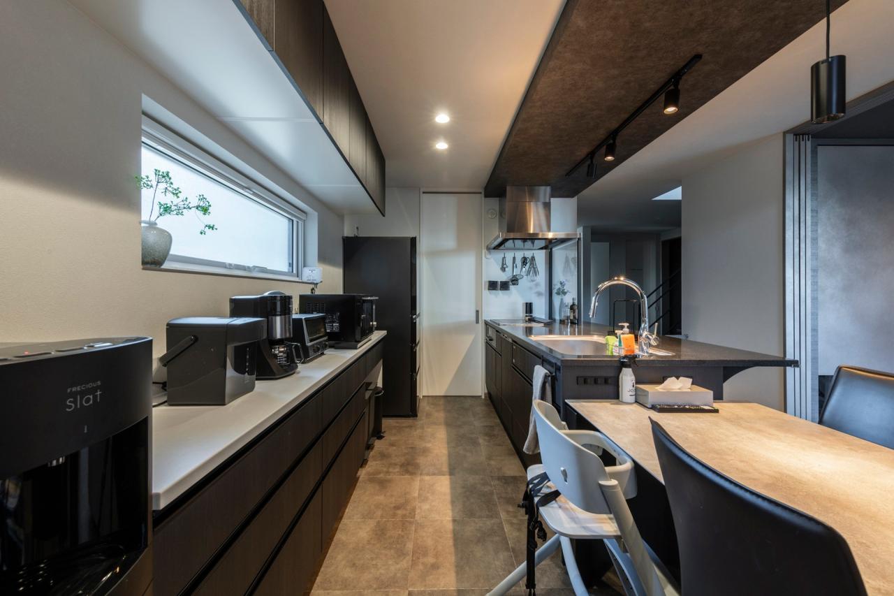 ダイニング、キッチン、収納：オーナー様の身長に合わせ高めの作業面にしたキッチン、吊戸棚も高く配置してより広さを感じる