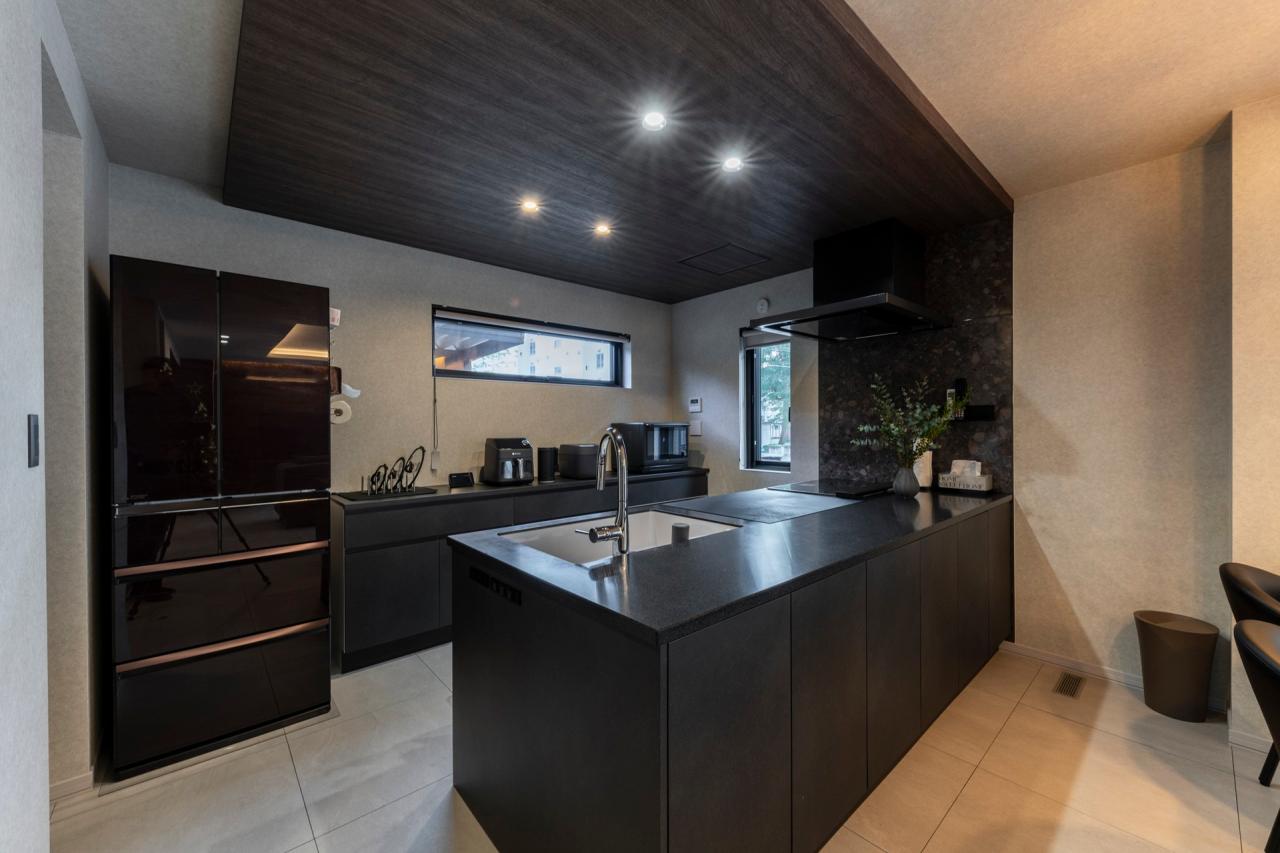 キッチン、壁紙：ダークトーンの木目調に貼り分けた下がり天井が丁度いいおこもり感を生む