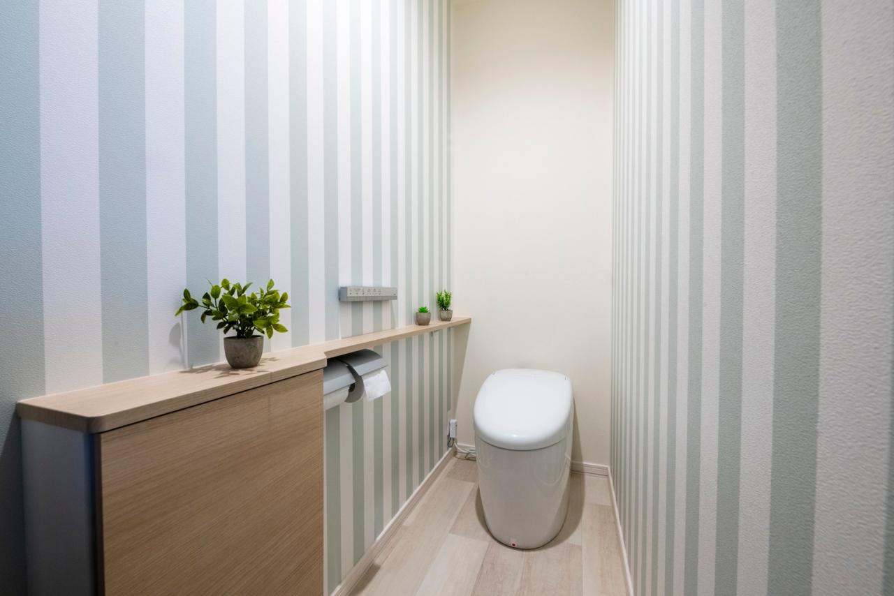 トイレ、壁紙：奥様の好みに合わせストライプのクロスが映える落ち着いた空間に