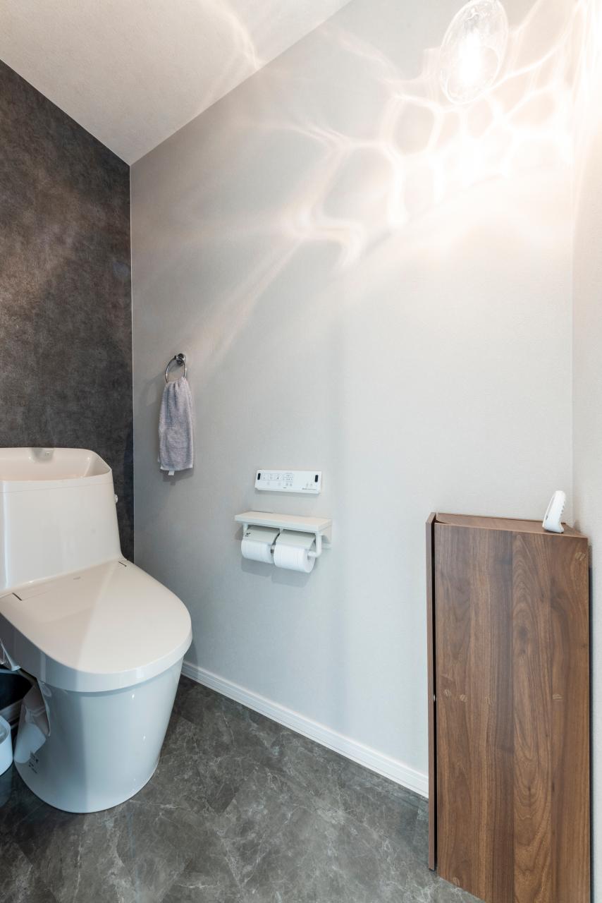 トイレ、壁紙、照明：2階トイレはシックなクロスと床材で落ち着いた印象に