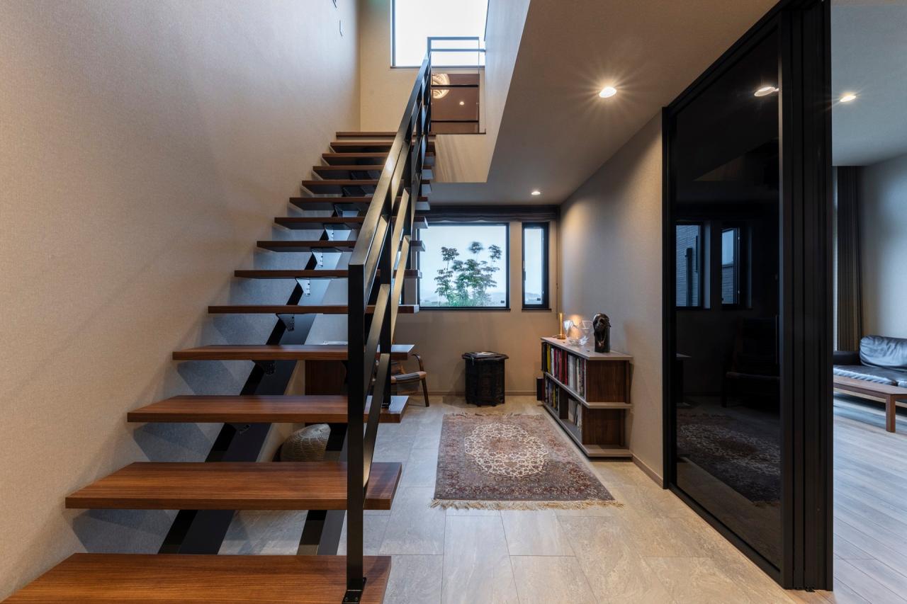 階段、ホール、フリースペース：オープン階段の下にはおこもり感が落ち着きを生むライブラリースペース