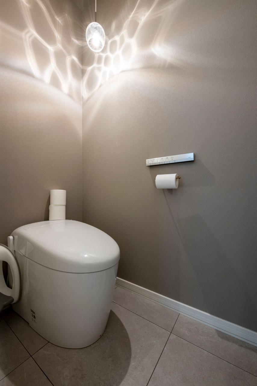 トイレ、収納、壁紙：トイレはペンダントライトが映えるダークトーンのクロスでまとめ、落ち着いた印象に