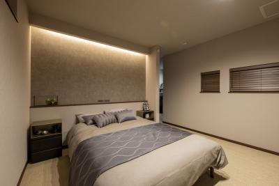 寝室：主寝室。ベッドヘッドの上部の間接照明が部屋をやわらかく照らす。
