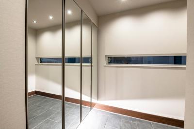 玄関：シューズボックスの扉に鏡を採用、空間に広がりを感じる