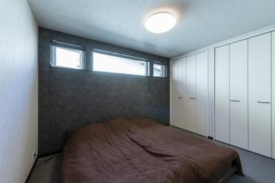 寝室：主寝室はスリット窓とアクセントクロスでデザイン