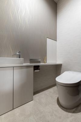 トイレ、壁紙：さりげない金色が映えるクロスを採用したレストルーム