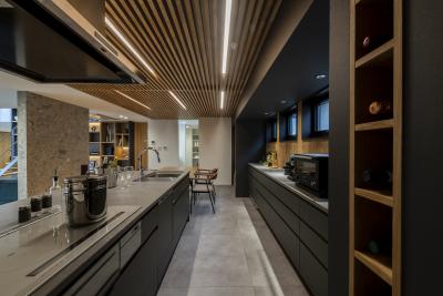 キッチン：床と対照的な木のルーバーの組み合わせで雰囲気を醸し出したキッチン